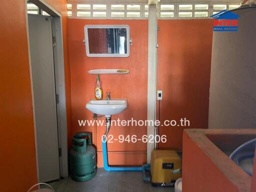 Compact bathroom with basic amenities and storage area