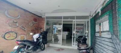 Entrance of a modern residential building with motorcycles parked outside