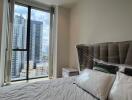 Modern bedroom with city view through large window