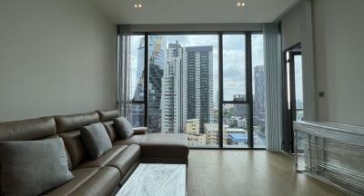 Modern living room with large windows showcasing city views