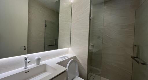 Modern bathroom with large mirror and marble walls