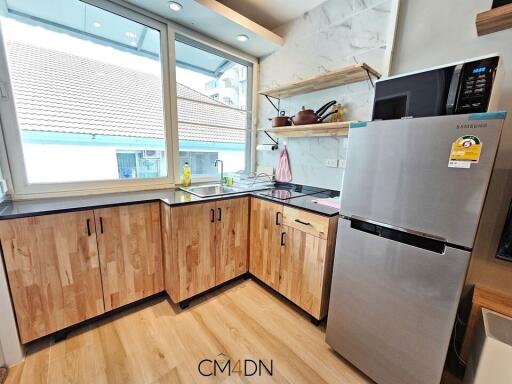 Modern kitchen with large windows and well-equipped appliances