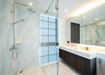 Spacious modern bathroom with glass shower and large mirror