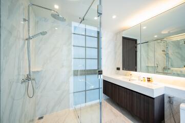 Spacious modern bathroom with glass shower and large mirror