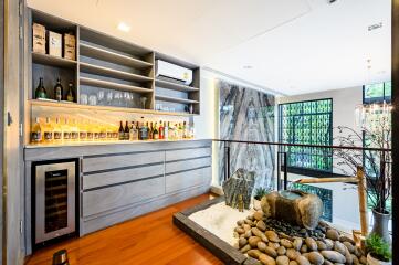 Elegant home bar setup in a modern living room with natural stone features