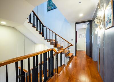 Elegant hallway interior with a polished wooden staircase and hardwood flooring