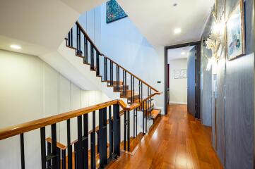 Elegant hallway interior with a polished wooden staircase and hardwood flooring