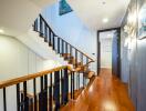 Elegant hallway interior with a polished wooden staircase and hardwood flooring