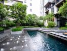 Luxurious outdoor communal swimming pool area with modern seating and lush greenery