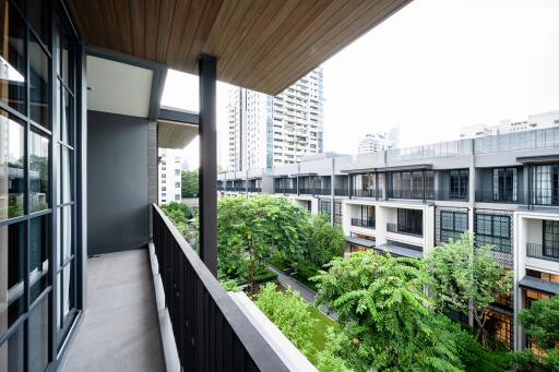 Spacious balcony overlooking lush greenery and modern buildings