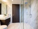Modern bathroom interior with marble finish and glass shower doors