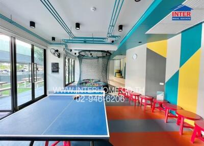 Spacious recreation room with ping pong table and bright color scheme