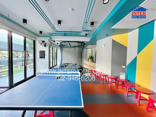 Spacious recreation room with ping pong table and bright color scheme