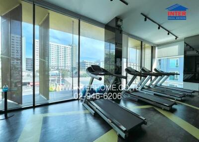 Modern apartment gym with large windows and city view