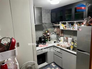 Compact residential kitchen with various appliances and utensils