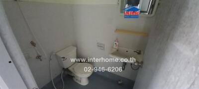 Compact bathroom with white tiles and essential fixtures