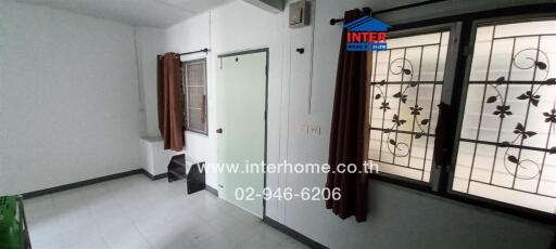 Spacious and Bright Living Room with Large Windows and Security Grills