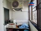 Compact kitchen space with a large window and air conditioning unit