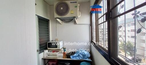 Compact kitchen space with a large window and air conditioning unit