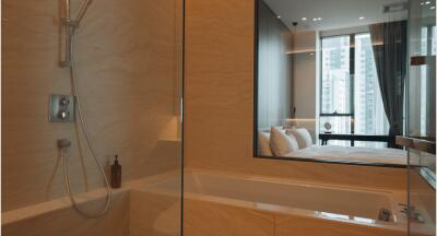 Modern bathroom with view into bedroom featuring large windows and cityscape