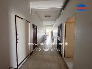 Long residential building hallway with multiple doors