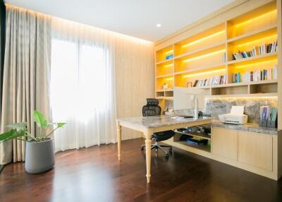 Bright home office with large desk and bookshelves