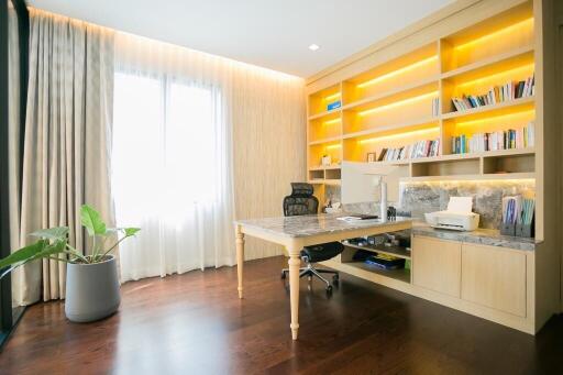 Bright home office with large desk and bookshelves