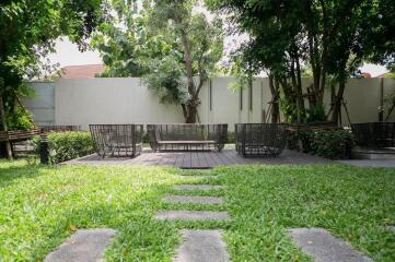 Spacious garden area with lush green lawn and modern seating arrangement