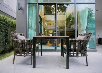 Contemporary patio with stylish furniture and lush green surroundings