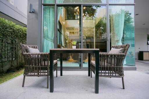 Contemporary patio with stylish furniture and lush green surroundings