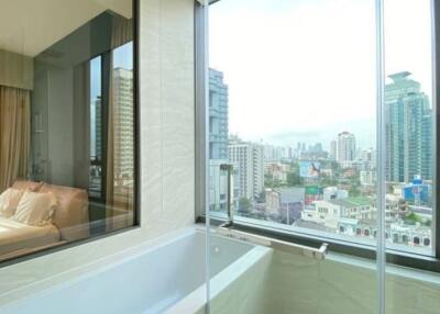 Modern bedroom with large windows offering cityscape views