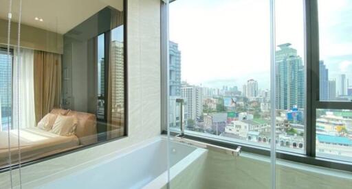 Modern bedroom with large windows offering cityscape views