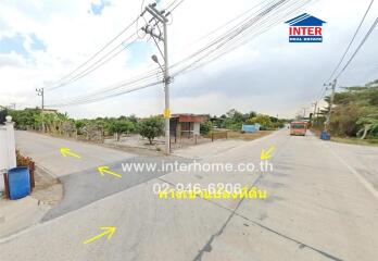 Paved suburban street with electrical poles and sparse traffic on a clear day