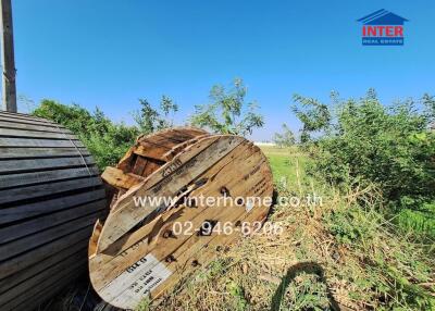 Rural outdoor scenery with large wooden spools and lush greenery