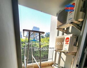 Compact balcony with air conditioning units and urban view