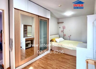Modern bedroom with wooden flooring and built-in wardrobe