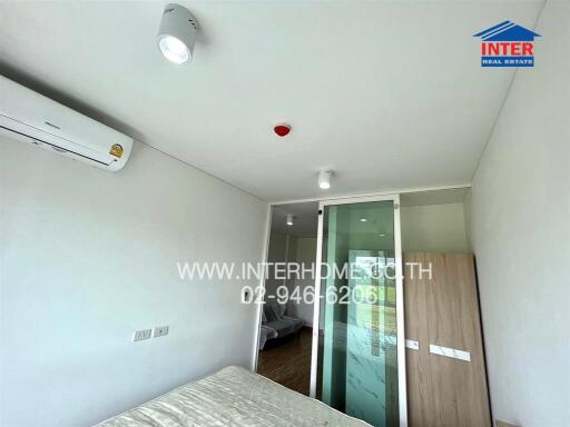 Modern bedroom with air conditioning and glass door leading to balcony