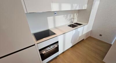 Modern minimalist kitchen interior with white cabinetry and built-in appliances