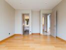 Spacious bedroom with wooden flooring and neutral walls