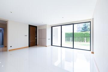 Spacious and bright living room with large windows and garden view