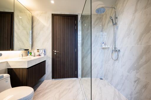 Modern bathroom with marble tiles, glass shower, and sleek fixtures