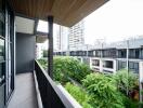 Spacious balcony with a view of urban greenery and neighboring buildings