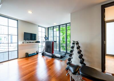 Spacious living room with exercise equipment and hardwood flooring