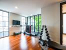 Spacious living room with exercise equipment and hardwood flooring
