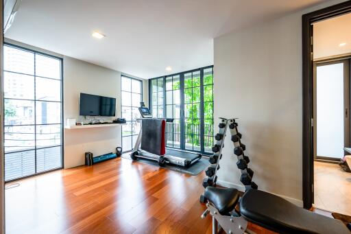 Spacious living room with exercise equipment and hardwood flooring