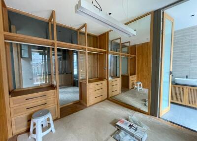 Spacious bedroom with large wooden wardrobe and attached bathroom