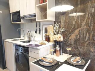 Modern compact kitchen with elegant stone backsplash and fully equipped with appliances