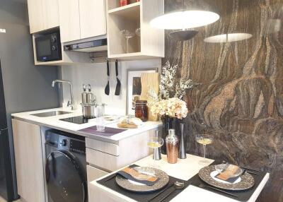 Modern compact kitchen with elegant stone backsplash and fully equipped with appliances