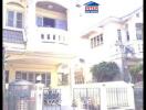 Exterior view of a two-story residential house with balconies and gated entrance