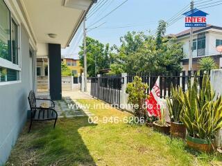 Cozy suburban house exterior with well-maintained garden and seating area